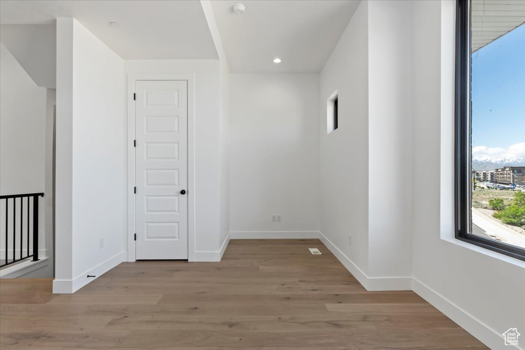 Unfurnished room with baseboards, light wood finished floors, recessed lighting, and a smoke detector