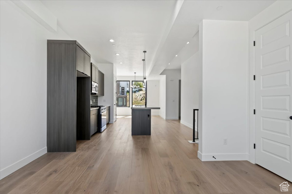 Kitchen featuring appliances with stainless steel finishes, baseboards, light wood-style flooring, a sink, and recessed lighting