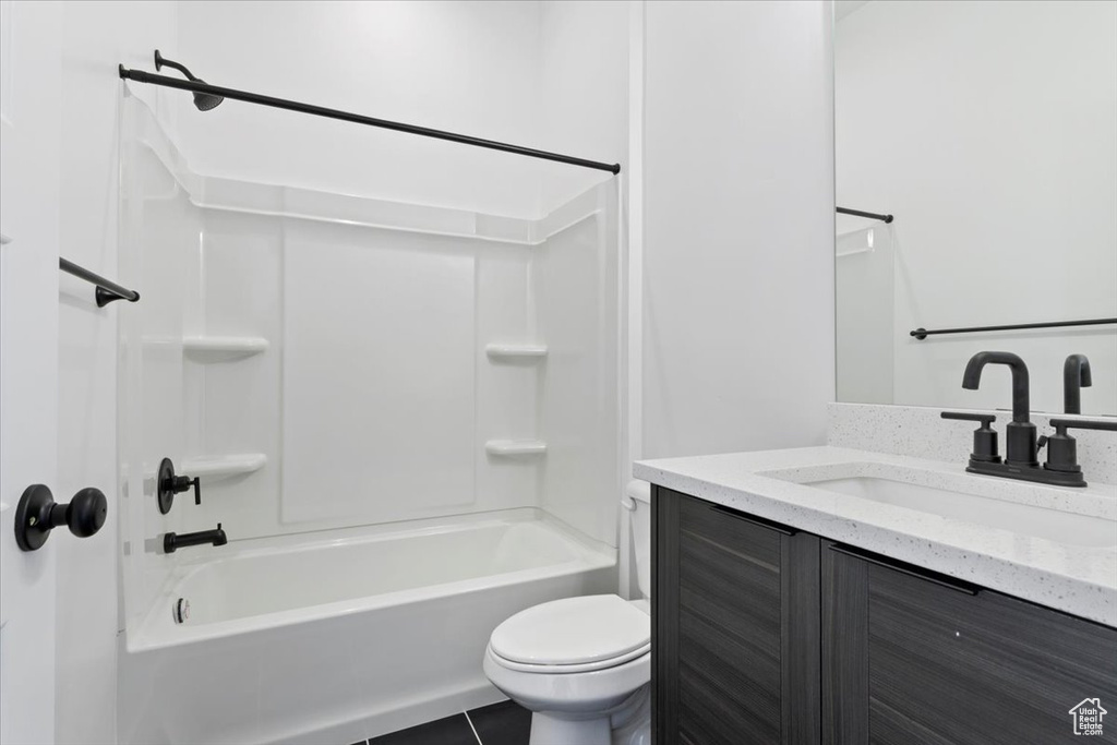 Bathroom with toilet, vanity, tile patterned floors, and bathing tub / shower combination