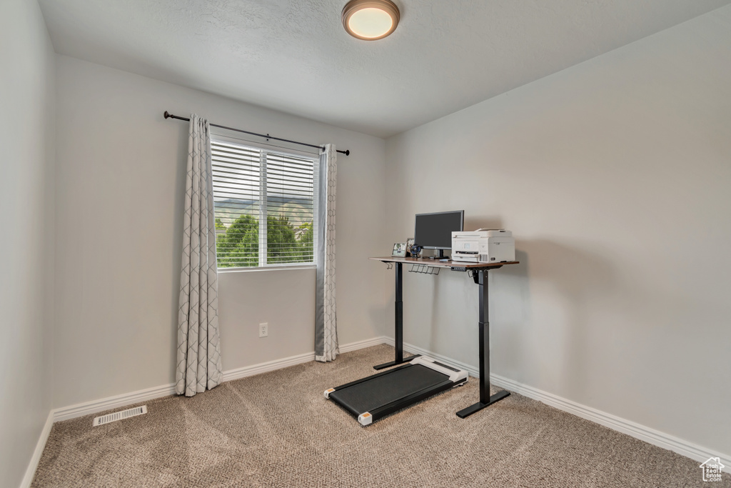 Exercise room with carpet floors and baseboards