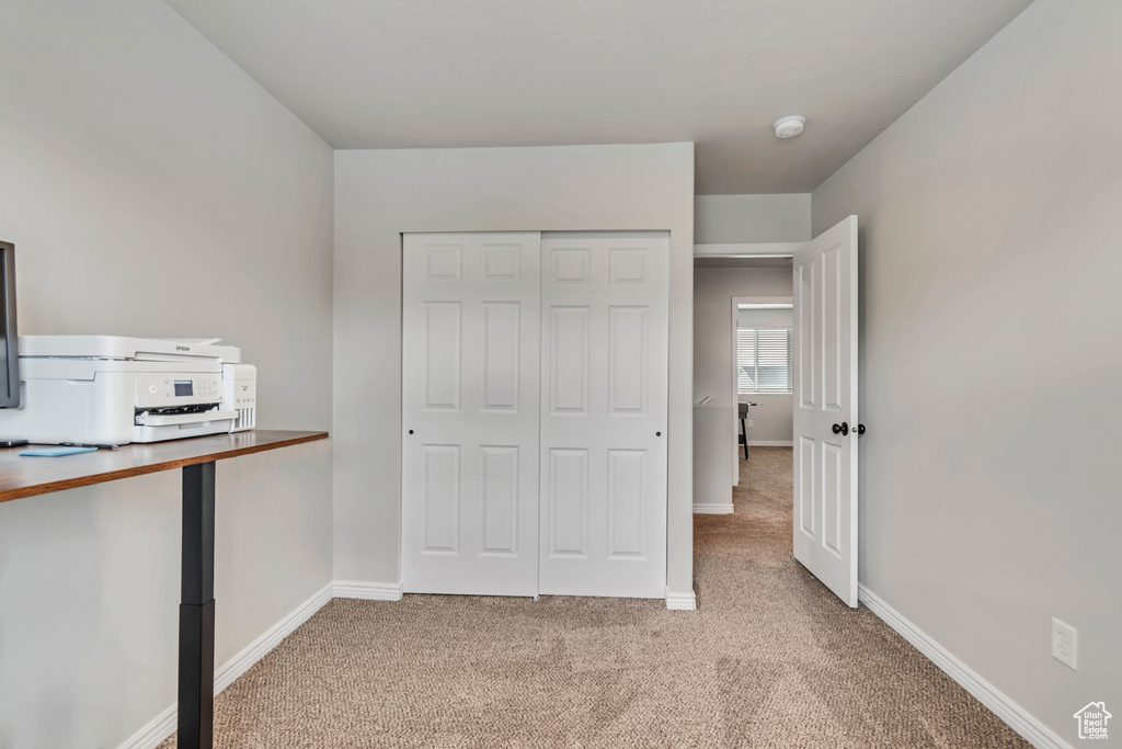 Unfurnished bedroom featuring carpet floors, baseboards, and a closet
