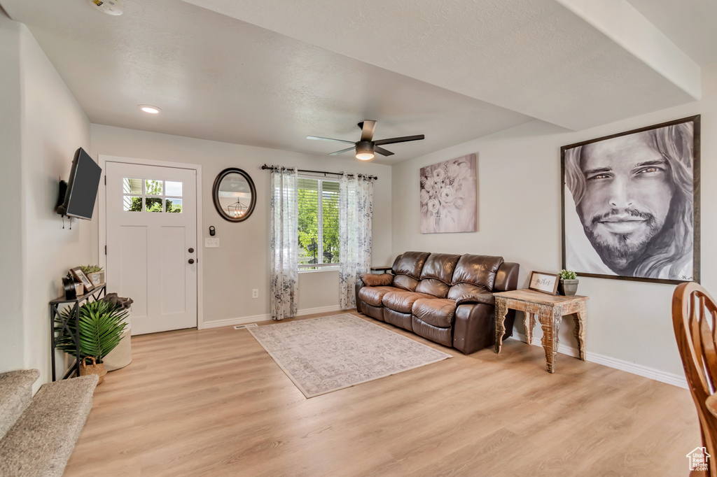 Living area with light wood finished floors, plenty of natural light, and baseboards