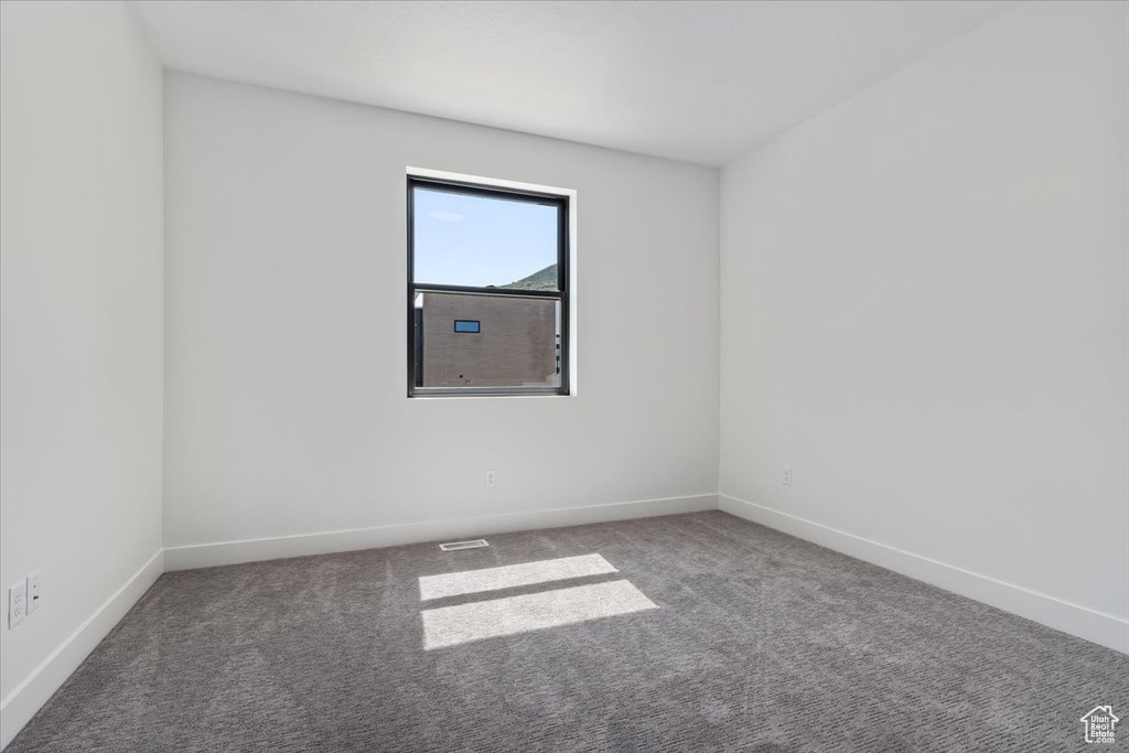 Carpeted empty room with baseboards