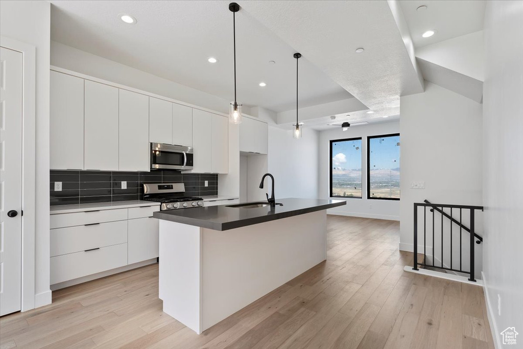 Kitchen featuring a sink, appliances with stainless steel finishes, modern cabinets, white cabinets, and recessed lighting