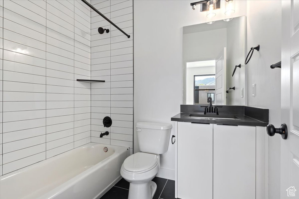 Full bathroom featuring toilet, vanity, tile patterned flooring, shower / tub combination, and baseboards