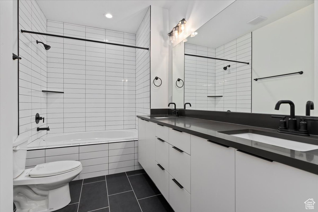 Full bathroom featuring toilet, tile patterned floors, recessed lighting, tiled shower / bath, and double vanity