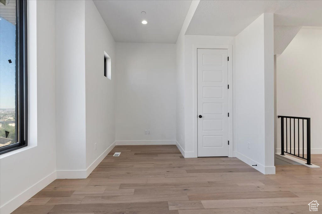 Empty room with plenty of natural light, baseboards, light wood-type flooring, and recessed lighting