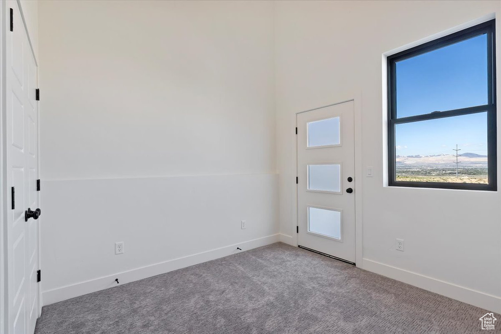 Carpeted foyer featuring baseboards