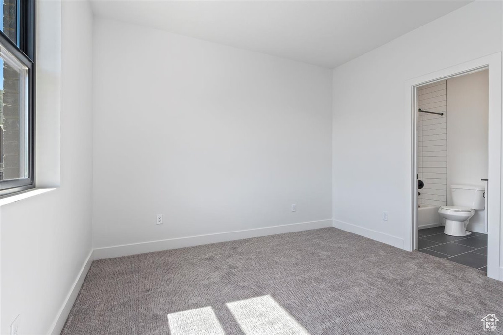 Unfurnished bedroom with carpet, baseboards, and ensuite bath