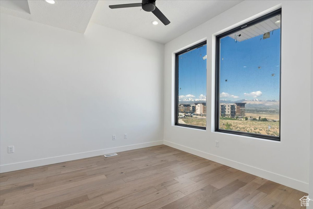 Spare room with light wood-type flooring, ceiling fan, baseboards, and recessed lighting