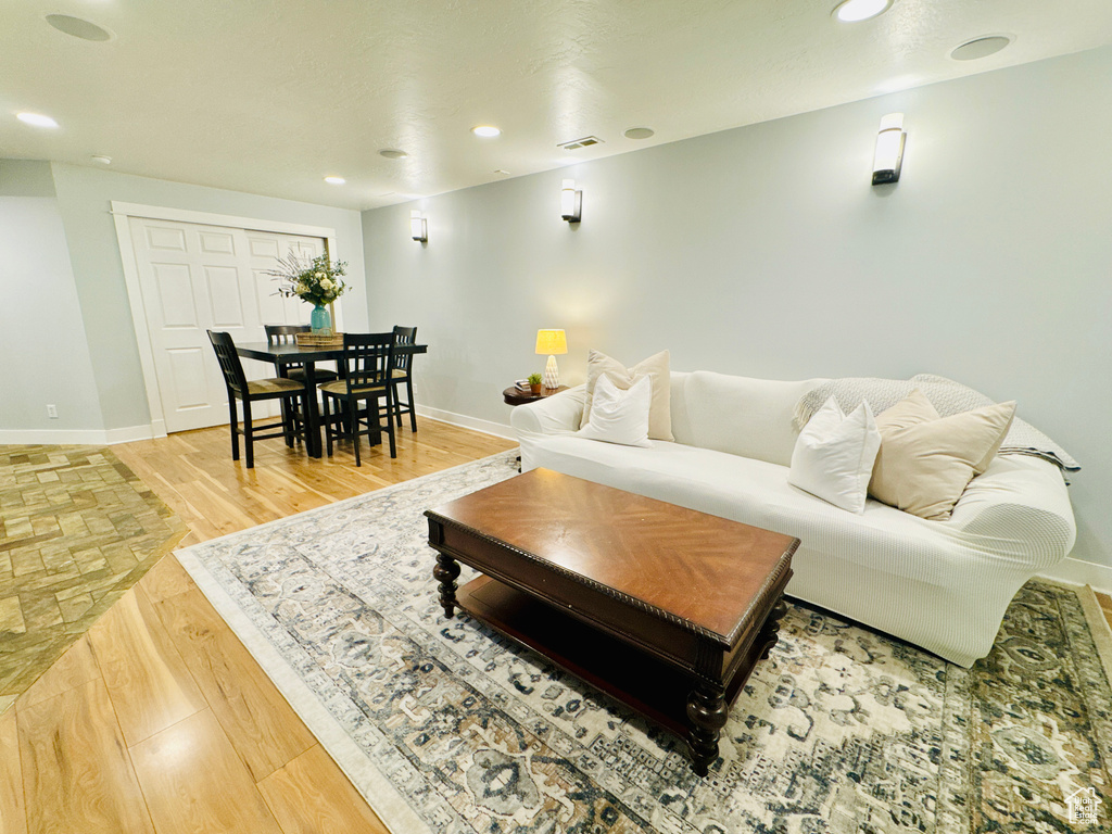 Living area featuring baseboards, recessed lighting, and light wood-type flooring