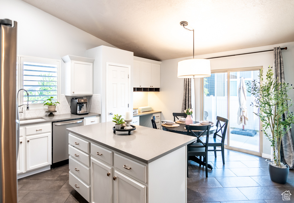 Kitchen with dishwasher, healthy amount of natural light, white cabinets, and lofted ceiling