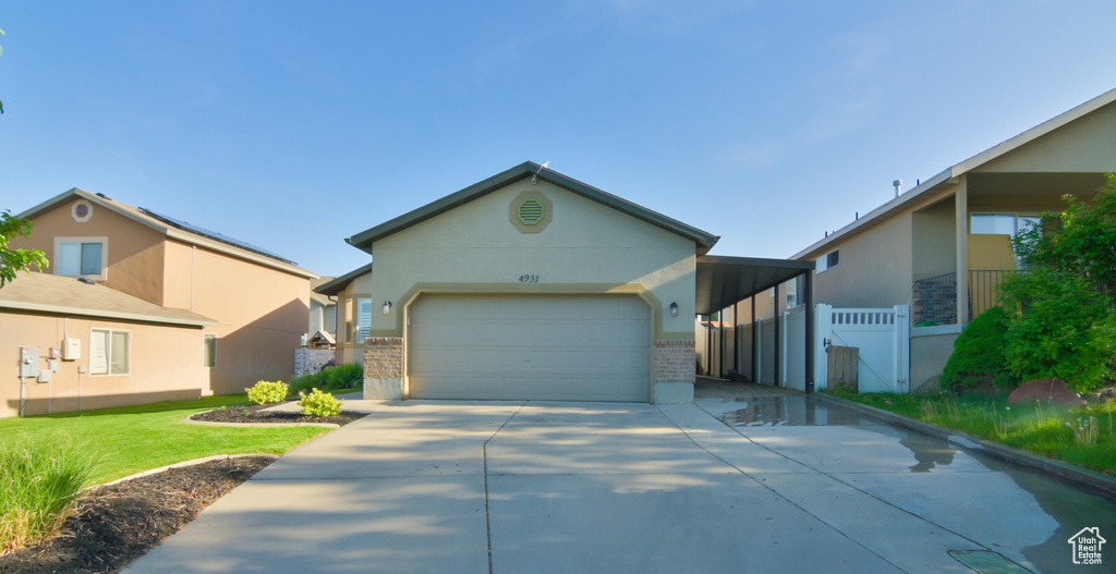 View of front of property featuring concrete driveway, a garage, brick siding, and stucco siding