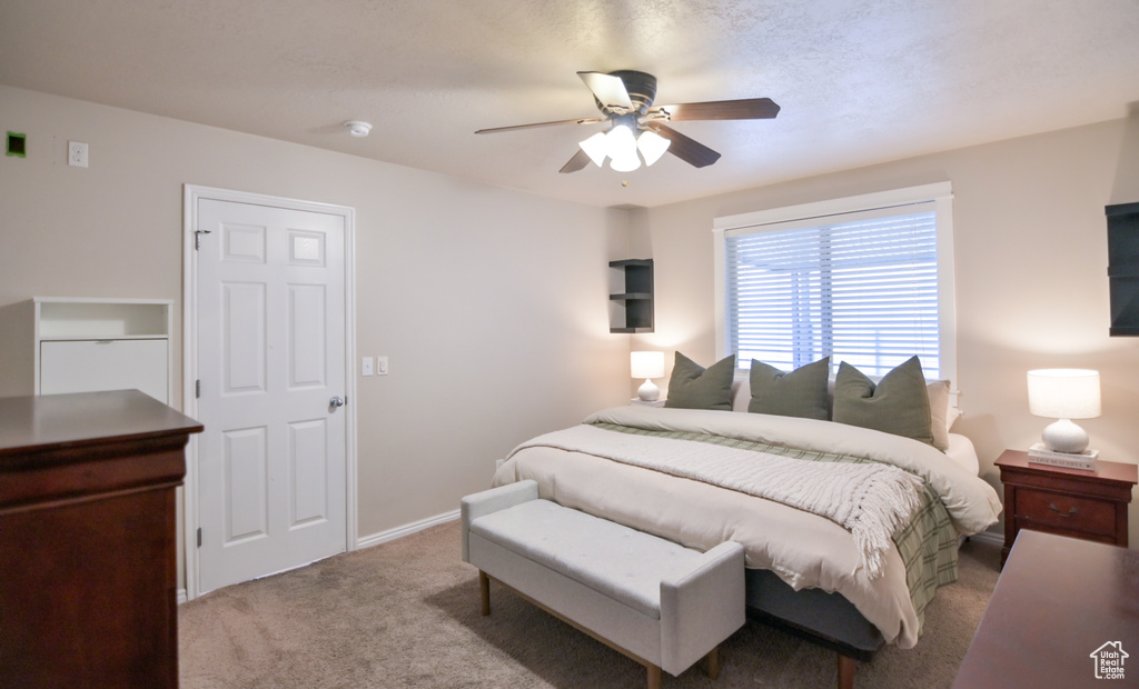 Carpeted bedroom featuring a ceiling fan and baseboards
