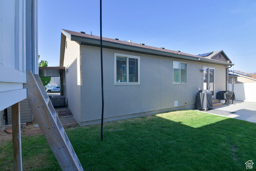 Back of house featuring central AC, stucco siding, and a patio