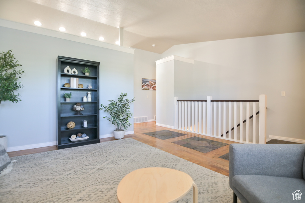 Living room featuring wood finished floors, vaulted ceiling, recessed lighting, and baseboards