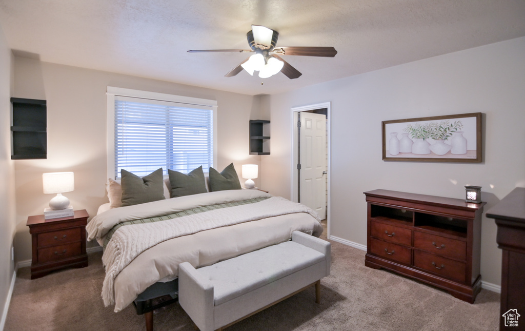 Carpeted bedroom with baseboards and a ceiling fan