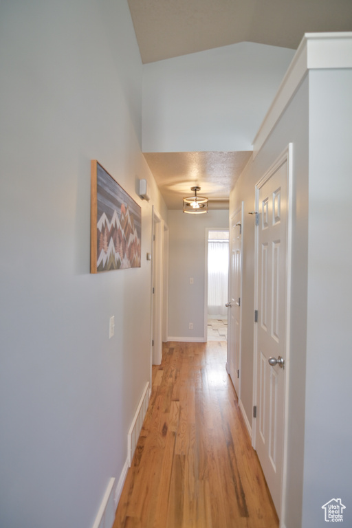Hallway featuring light wood finished floors and baseboards