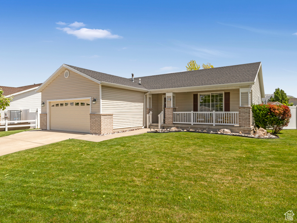 Ranch-style home with a porch, brick siding, a garage, concrete driveway, and a front yard
