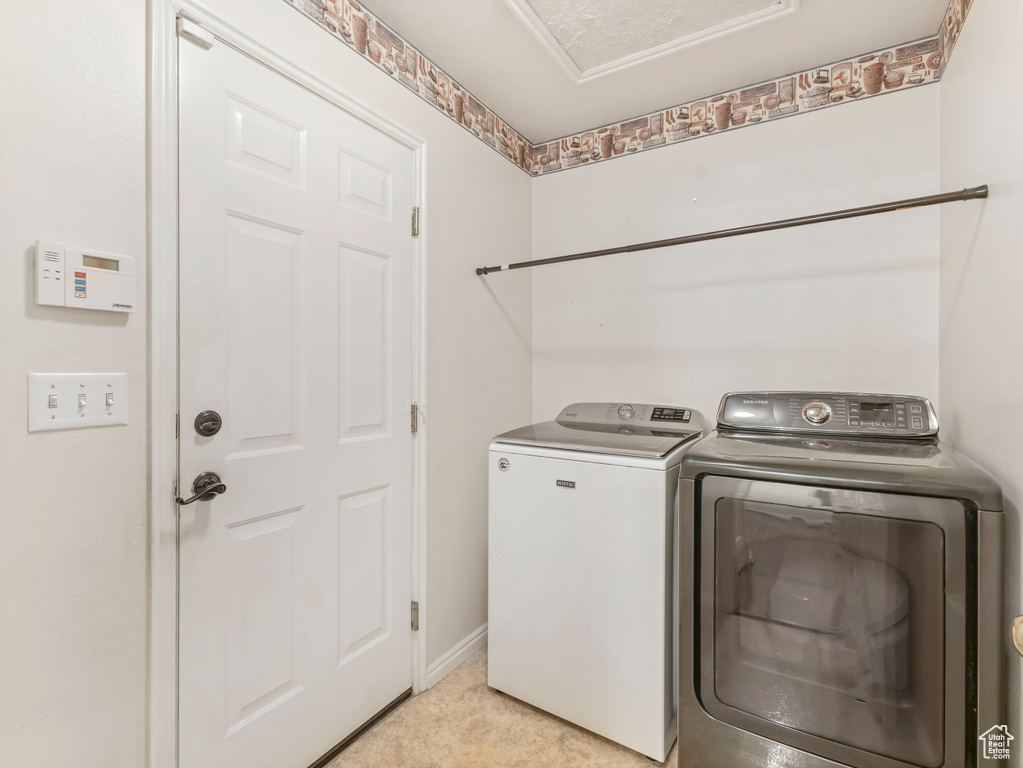 Clothes washing area with washer and clothes dryer and baseboards