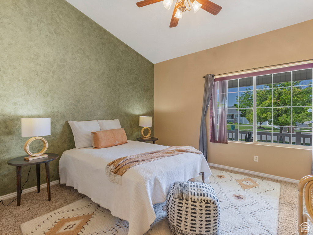 Bedroom featuring baseboards, carpet flooring, vaulted ceiling, and ceiling fan