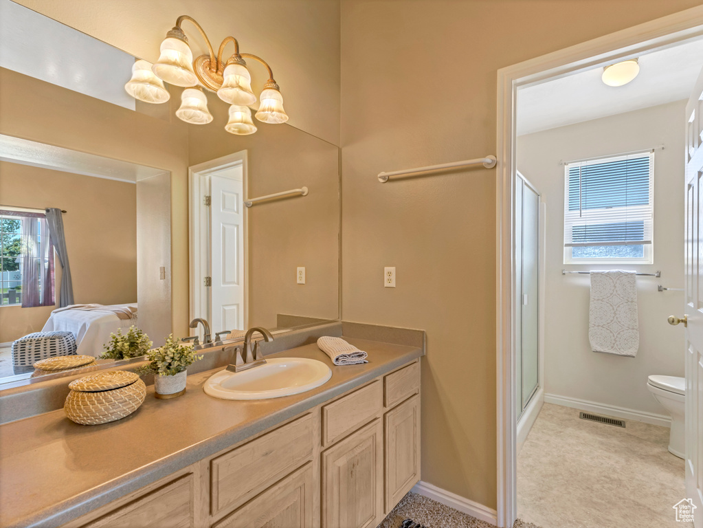Full bathroom with toilet, vanity, a shower stall, and ensuite bathroom
