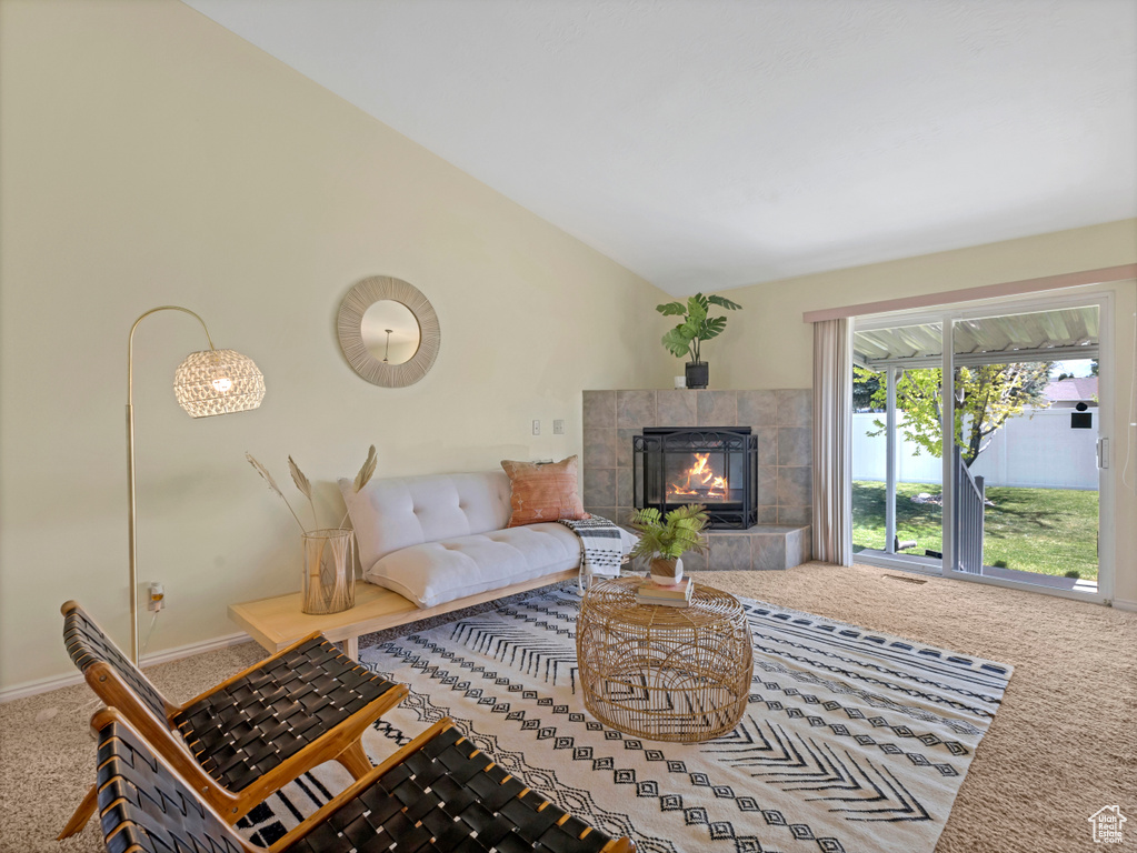 Living area featuring carpet floors, a fireplace, vaulted ceiling, and baseboards