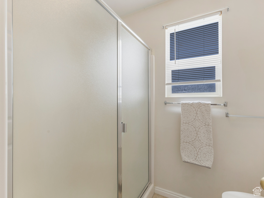 Full bathroom with a shower stall, toilet, and baseboards