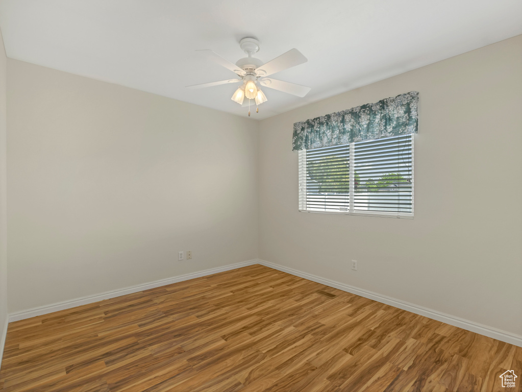 Unfurnished room with baseboards, wood finished floors, and ceiling fan