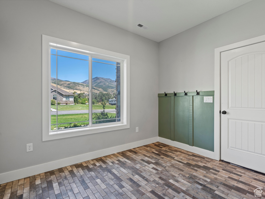 Unfurnished room featuring a mountain view and baseboards