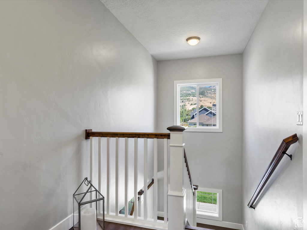 Staircase featuring a textured ceiling
