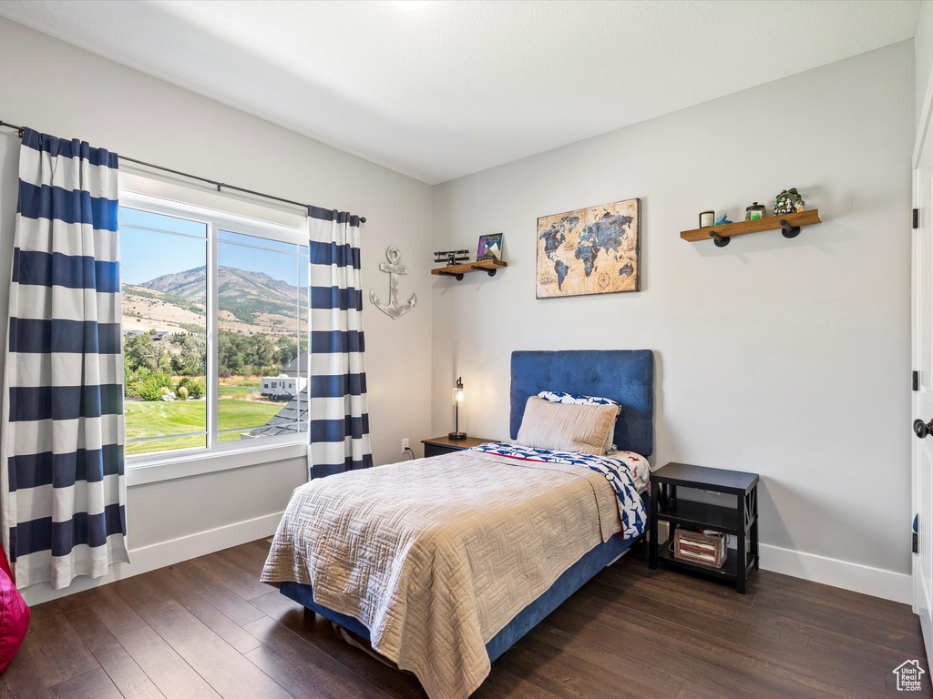 Bedroom featuring baseboards, wood-type flooring, and a mountain view