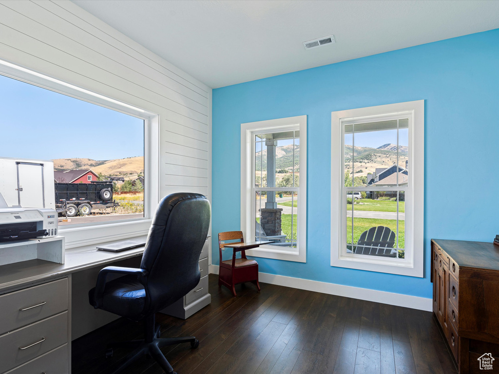 Home office featuring a mountain view, baseboards, and dark wood finished floors