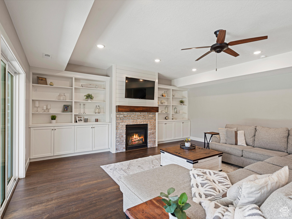Living room with a ceiling fan, dark wood-style floors, recessed lighting, baseboards, and a glass covered fireplace