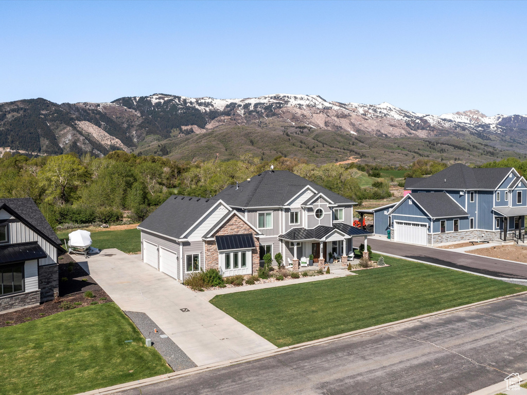 Craftsman inspired home with stone siding, concrete driveway, a standing seam roof, and a mountain view
