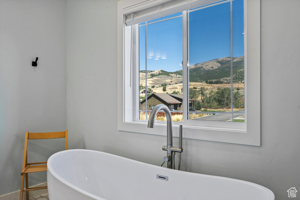 Full bathroom with a sink, a mountain view, a freestanding tub, and baseboards