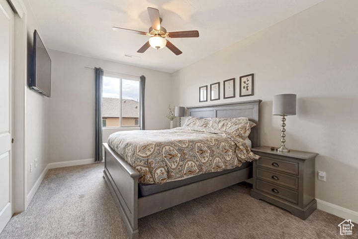 Carpeted bedroom with baseboards and ceiling fan