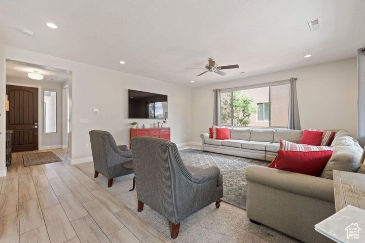 Living area featuring ceiling fan, light wood-style floors, baseboards, and recessed lighting
