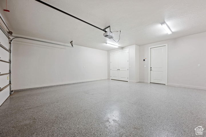 Garage featuring baseboards and a garage door opener