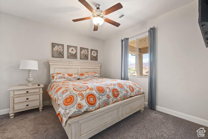 Carpeted bedroom with baseboards and a ceiling fan
