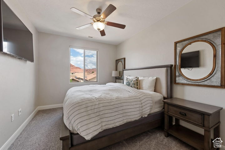 Carpeted bedroom featuring baseboards and a ceiling fan