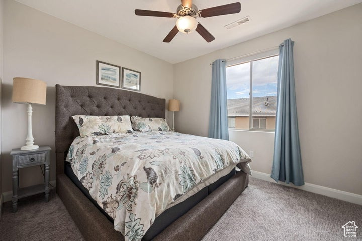 Bedroom with carpet floors, baseboards, and a ceiling fan