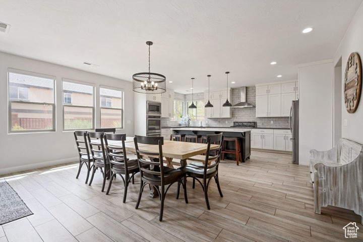 Dining area featuring a chandelier, light wood finished floors, recessed lighting, and baseboards