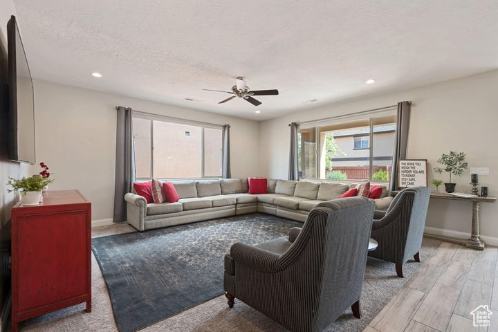Living area featuring ceiling fan, recessed lighting, baseboards, and light wood-style flooring