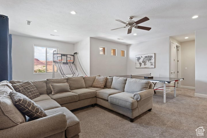 Living area with recessed lighting, light colored carpet, a ceiling fan, and baseboards