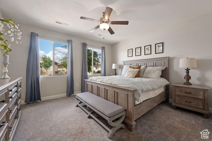 Carpeted bedroom featuring baseboards and a ceiling fan