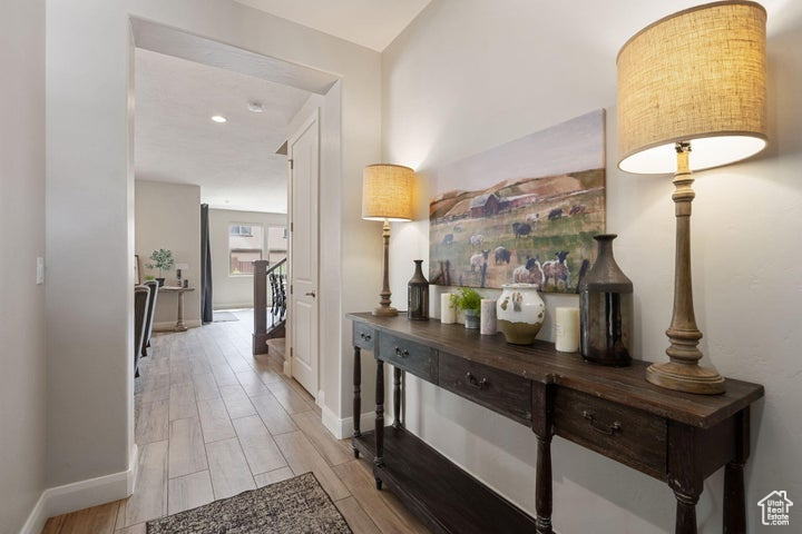 Corridor featuring light wood-type flooring, baseboards, and recessed lighting
