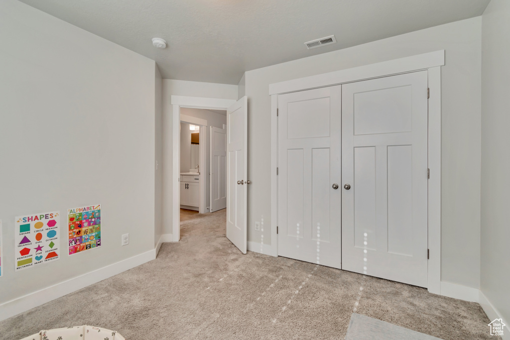 Unfurnished bedroom featuring carpet, baseboards, and a closet