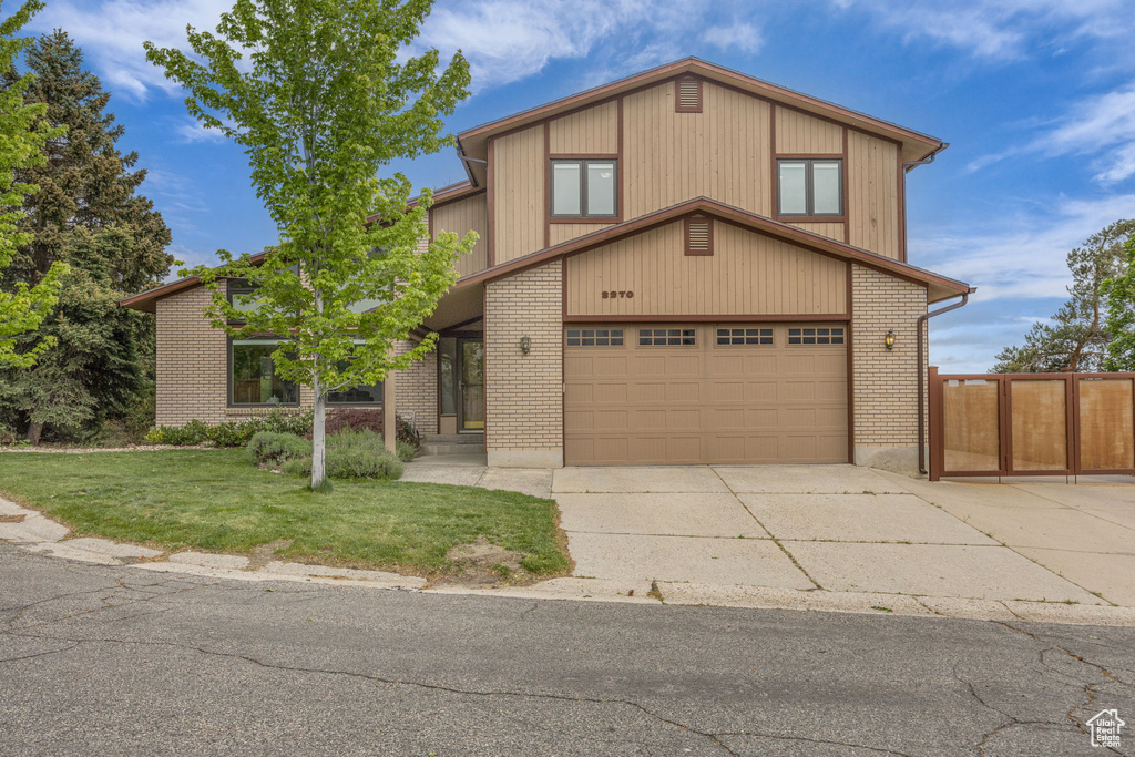 View of front of home featuring concrete driveway, brick siding, and an attached garage