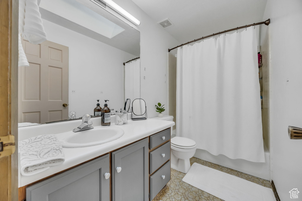 Full bathroom with vanity, toilet, and shower / bath combo